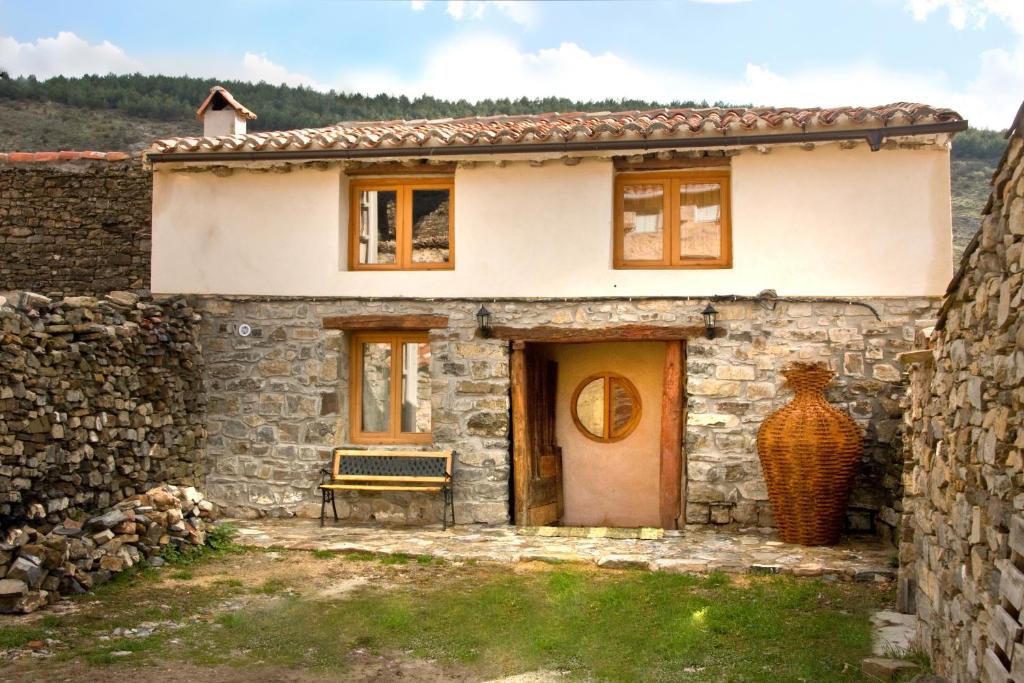 una casa de piedra con una puerta y un banco en Casa Grande, en Enciso