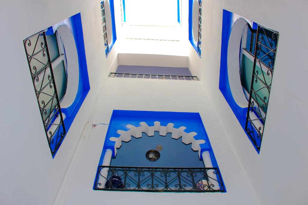 a building with blue and white walls and windows at Dar Bleu Pearl in Chefchaouene