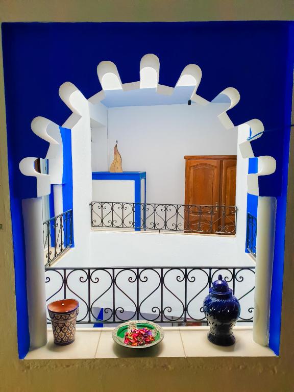 a shelf with vases sitting on a balcony at Dar Bleu Pearl in Chefchaouene