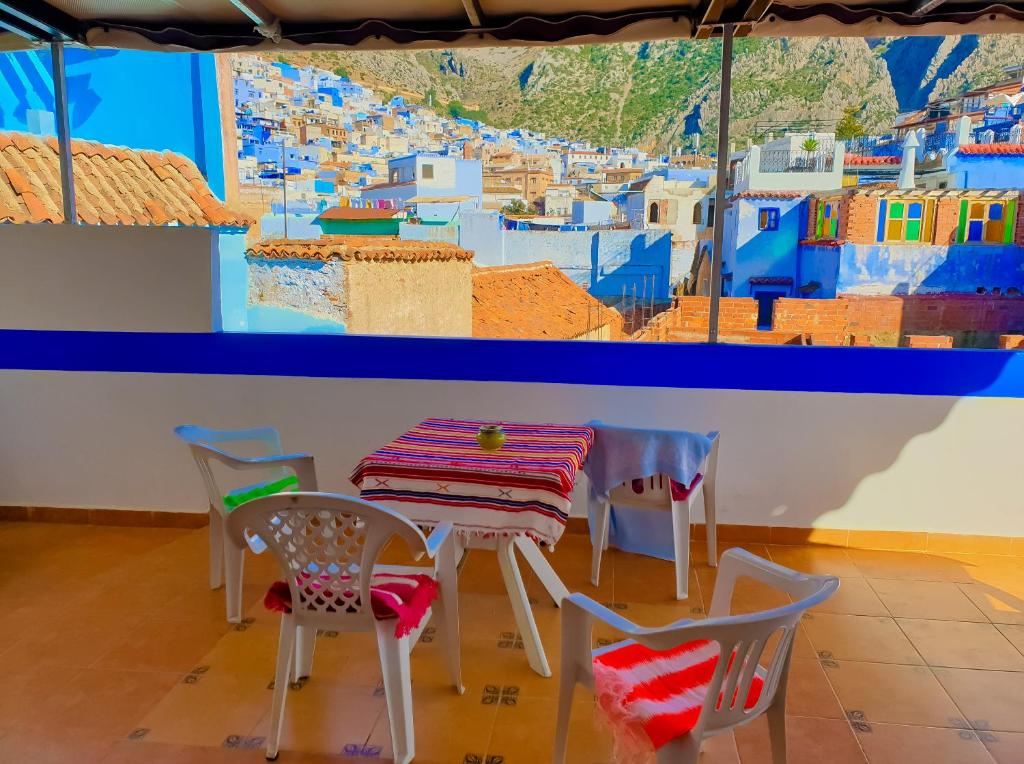 a table and chairs with a view of a city at Dar Bleu Pearl in Chefchaouene
