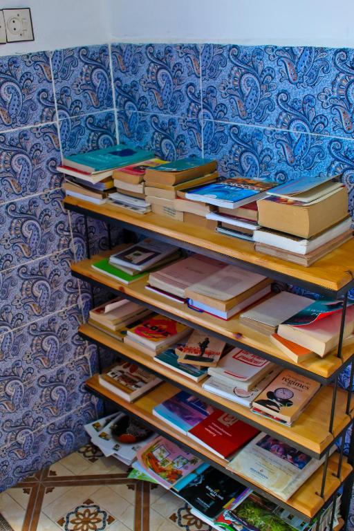 a stack of books sitting on a shelf at Dar Bleu Pearl in Chefchaouene
