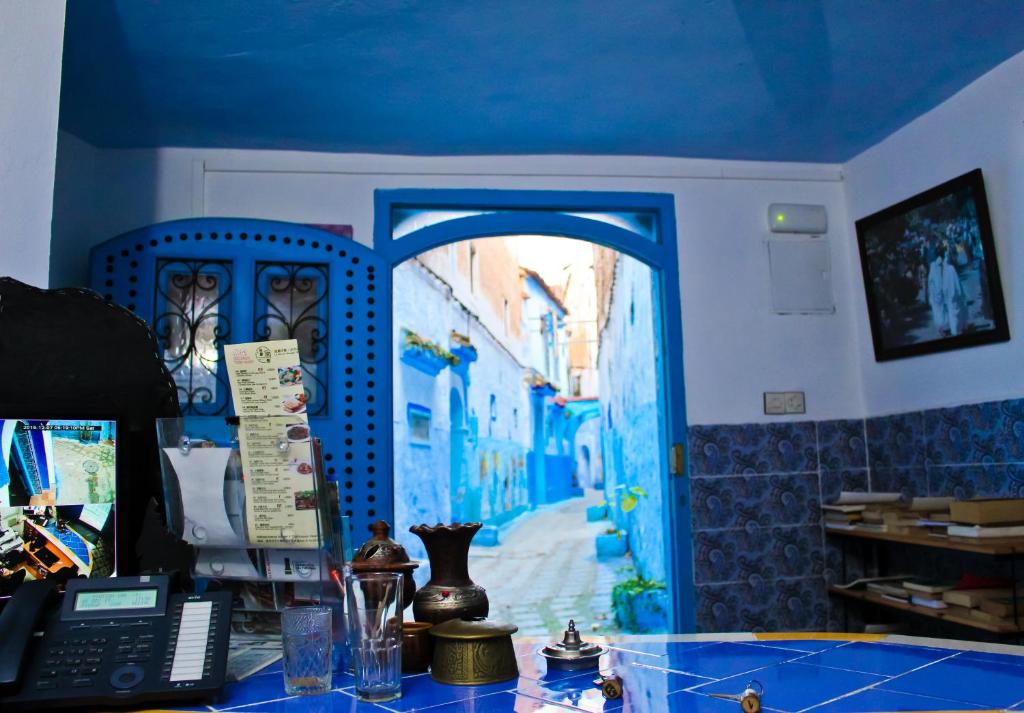 a room with a blue door and a desk with a computer at Dar Bleu Pearl in Chefchaouene