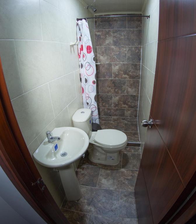a bathroom with a toilet and a sink at Kimaná Hostal in Santa Rosa de Cabal