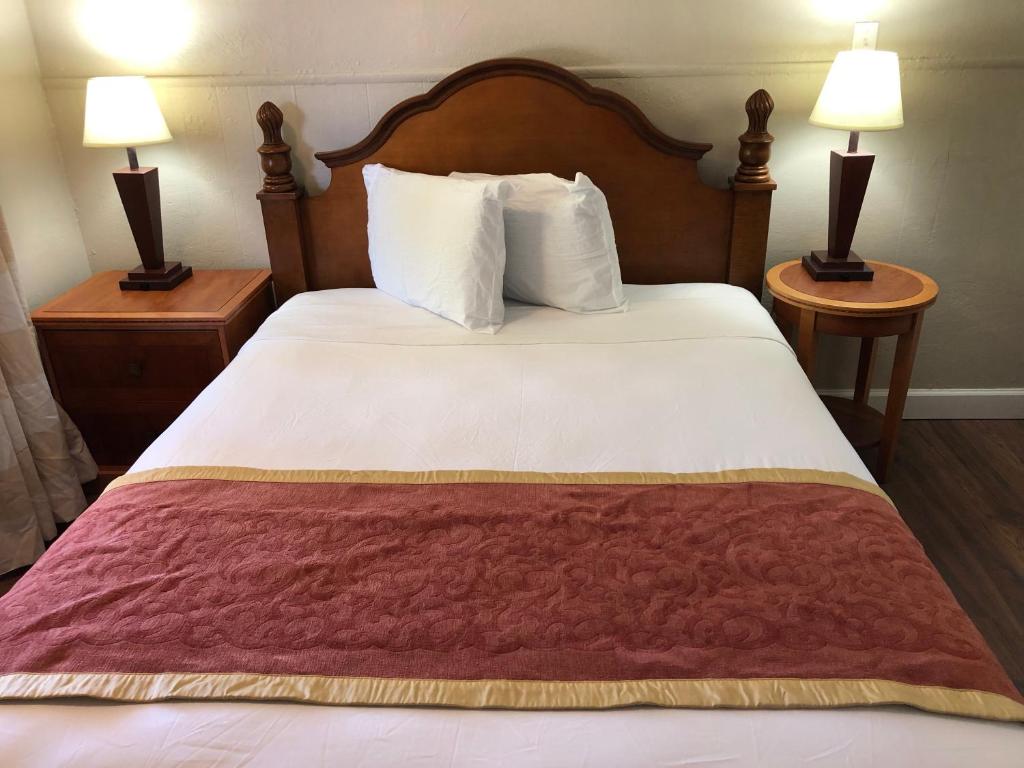 Cama en habitación de hotel con 2 mesitas de noche en Ocala Cove Motel, en Ocala