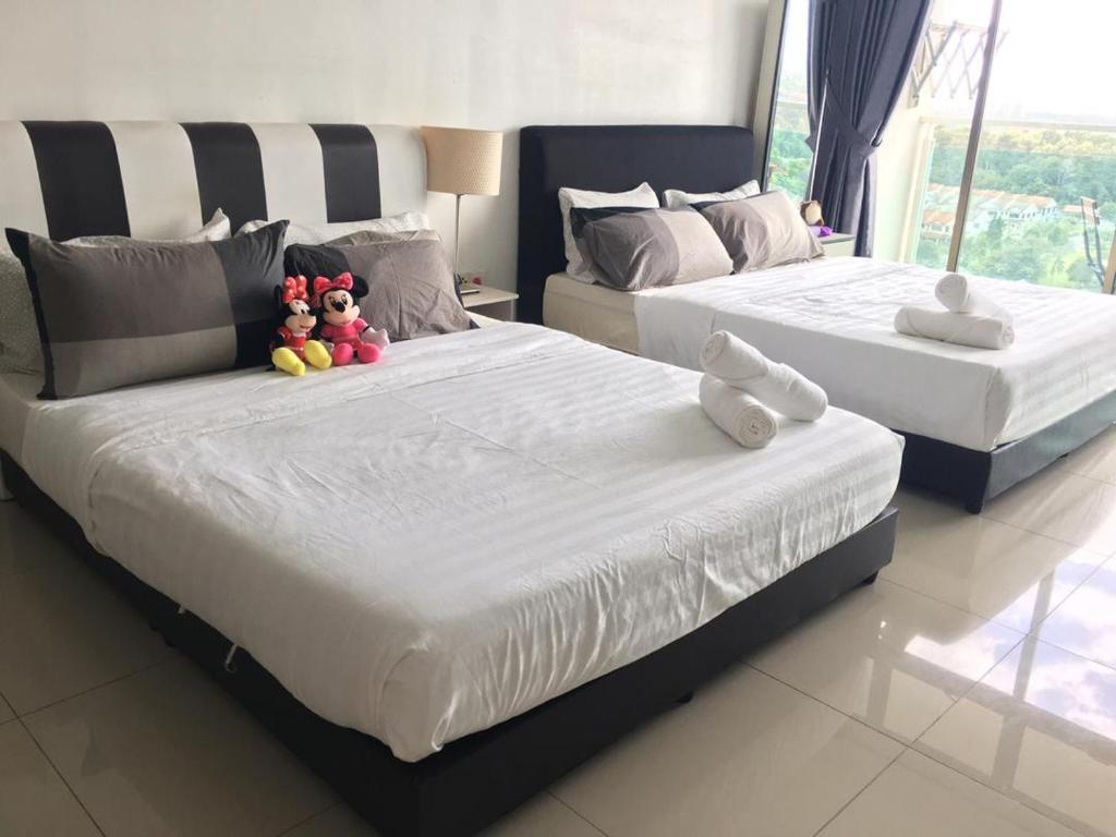 two beds with stuffed animals sitting on them in a bedroom at PALAZIO CONDO (MOUNT AUSTIN) in Johor Bahru