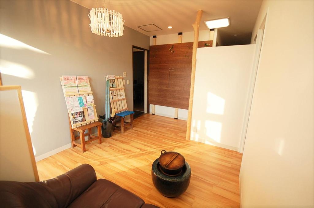 a living room with a hat sitting on the floor at 西条ゲストハウス八反 in Higashihiroshima