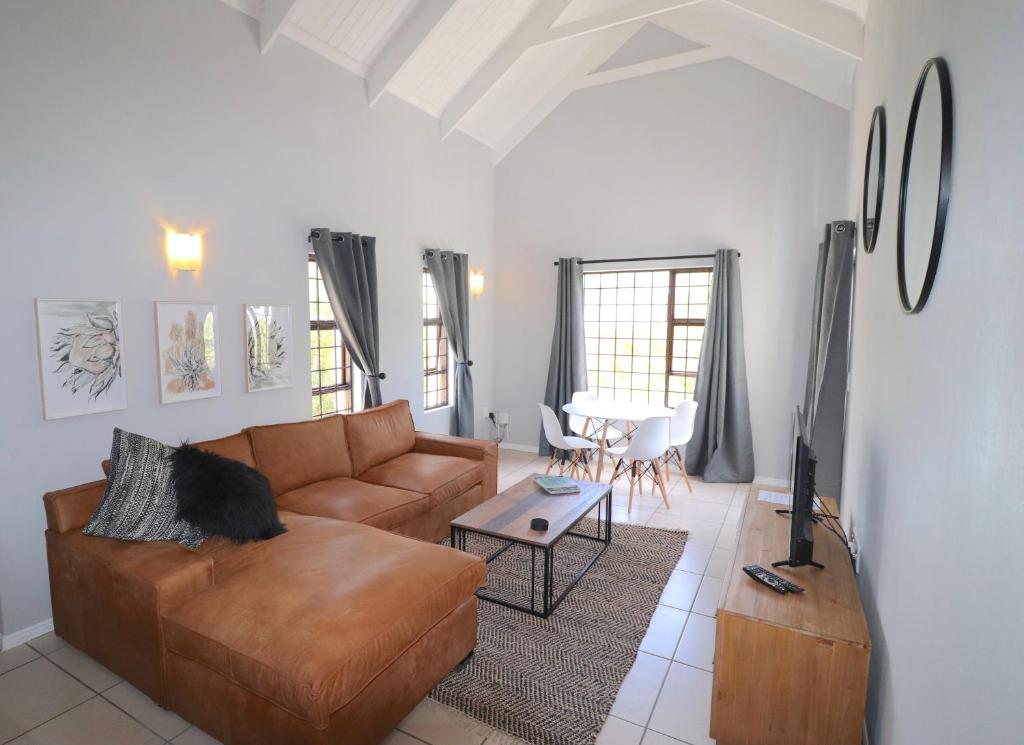 a living room with a couch and a table at Carole's Cottage in Hermanus