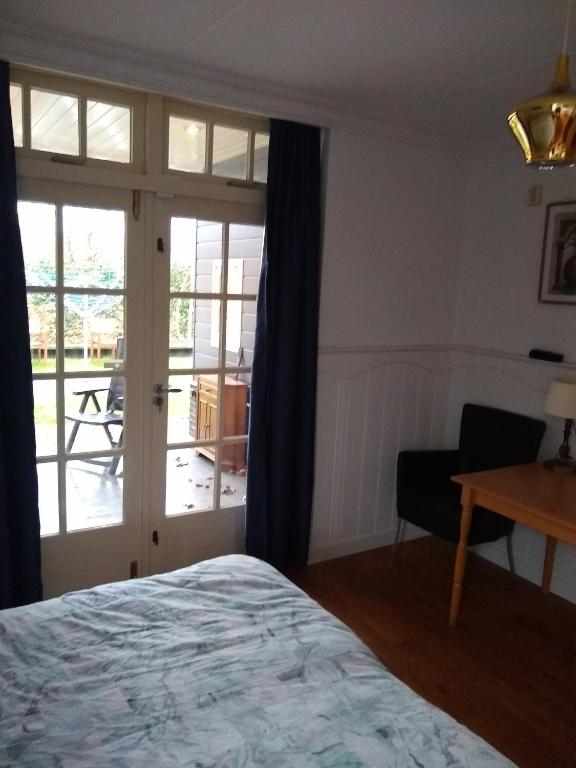 a bedroom with a bed and a sliding glass door at Folmerhuis in Oostkapelle