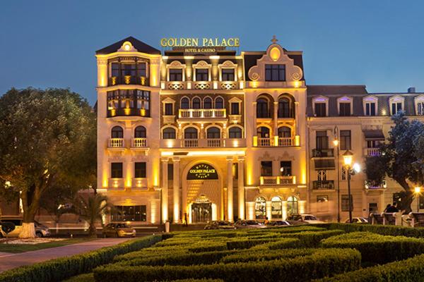 un grand bâtiment avec un panneau en haut dans l'établissement Golden Palace Batumi Hotel & Casino, à Batoumi