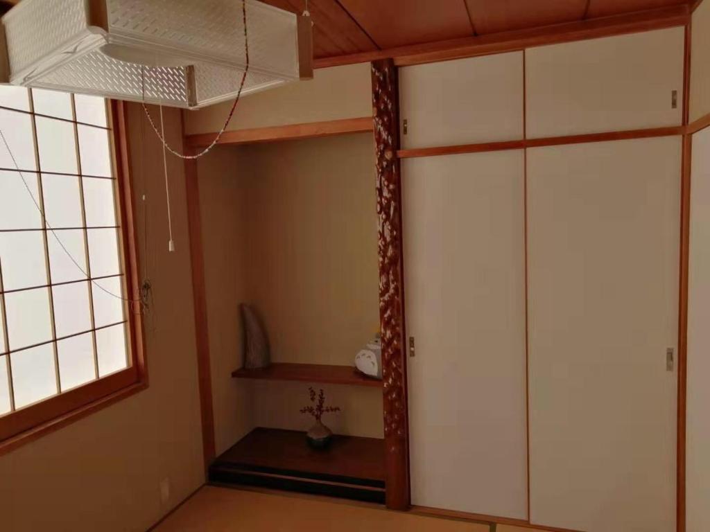 um quarto com um armário, uma janela e uma ventoinha em 駅近-最大収容9人JR小岩駅まで徒歩圏Leo小岩301 em Tóquio