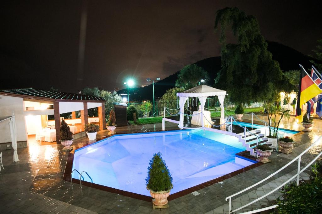 a swimming pool at night with a gazebo at Hotel Diecimare in Cava deʼ Tirreni