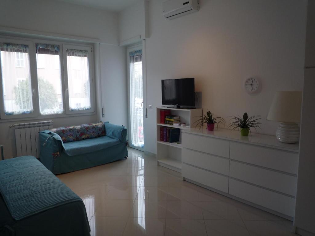 ein Wohnzimmer mit einem blauen Sofa und einem TV in der Unterkunft A casa di Elsa in Rom