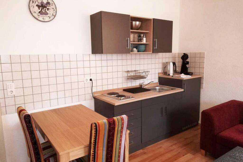 a kitchen with a table and a sink and a counter at Ferienwohnung - Apartment mit Balkon in Halle-Saale, Trotha in Halle an der Saale
