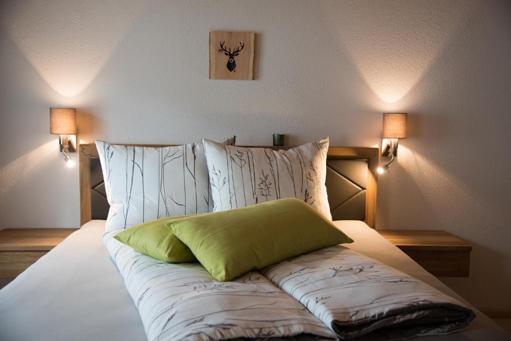 a bed with a green pillow on top of it at Ferienhaus Alpsteig in Schattwald