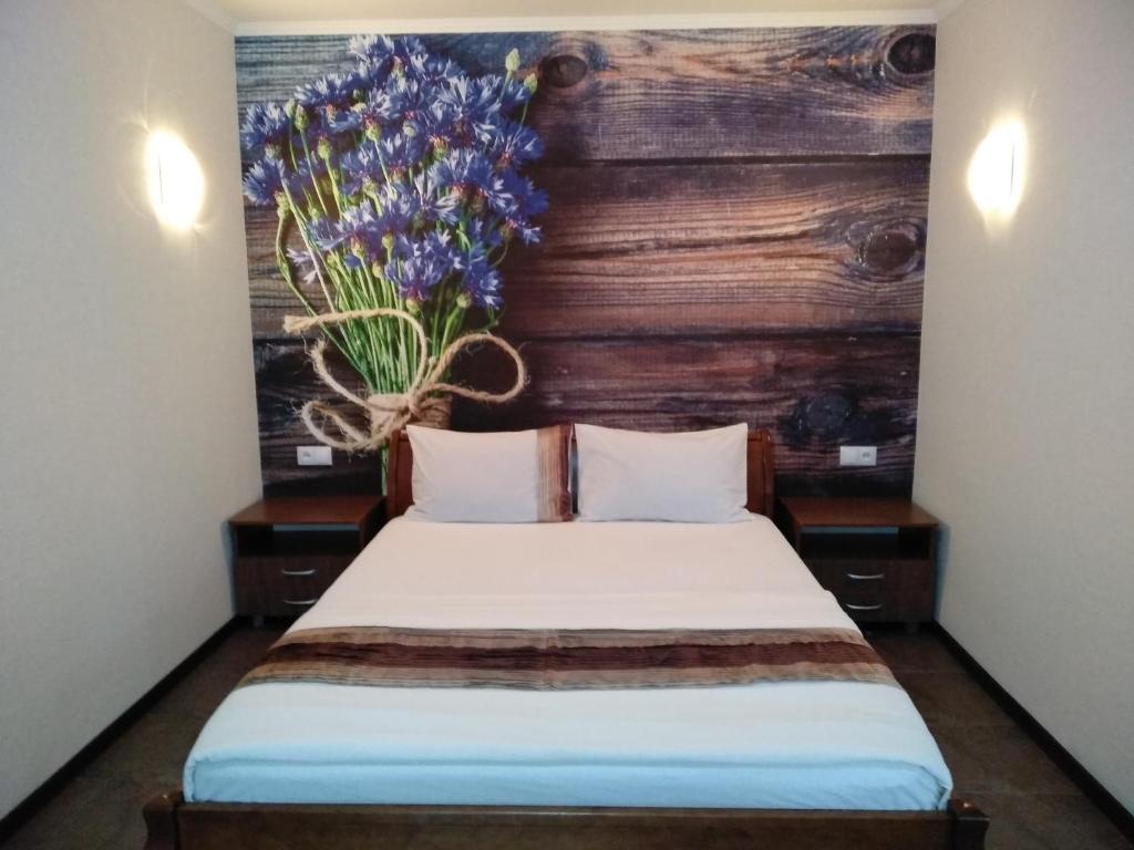 una camera da letto con un letto e un vaso di fiori sul muro di Comfortable apartment in the center a Černihiv