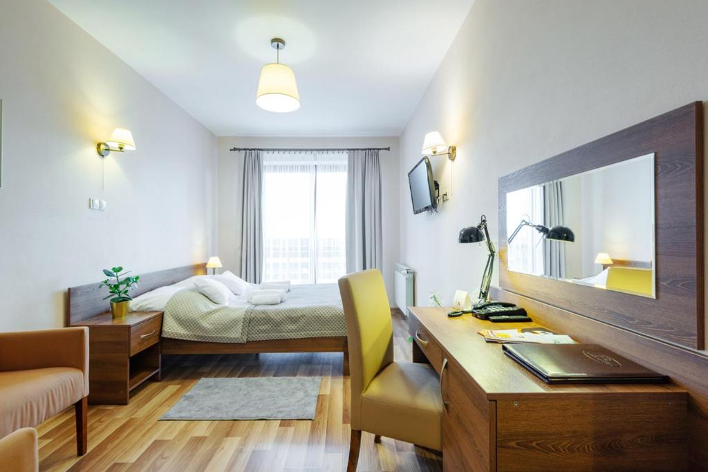- une chambre avec un bureau et un lit avec un miroir dans l'établissement Hotel Łokietek, à Czajowice