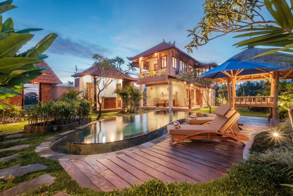 een huis met een zwembad en een houten terras bij A home, like a dream in Ubud
