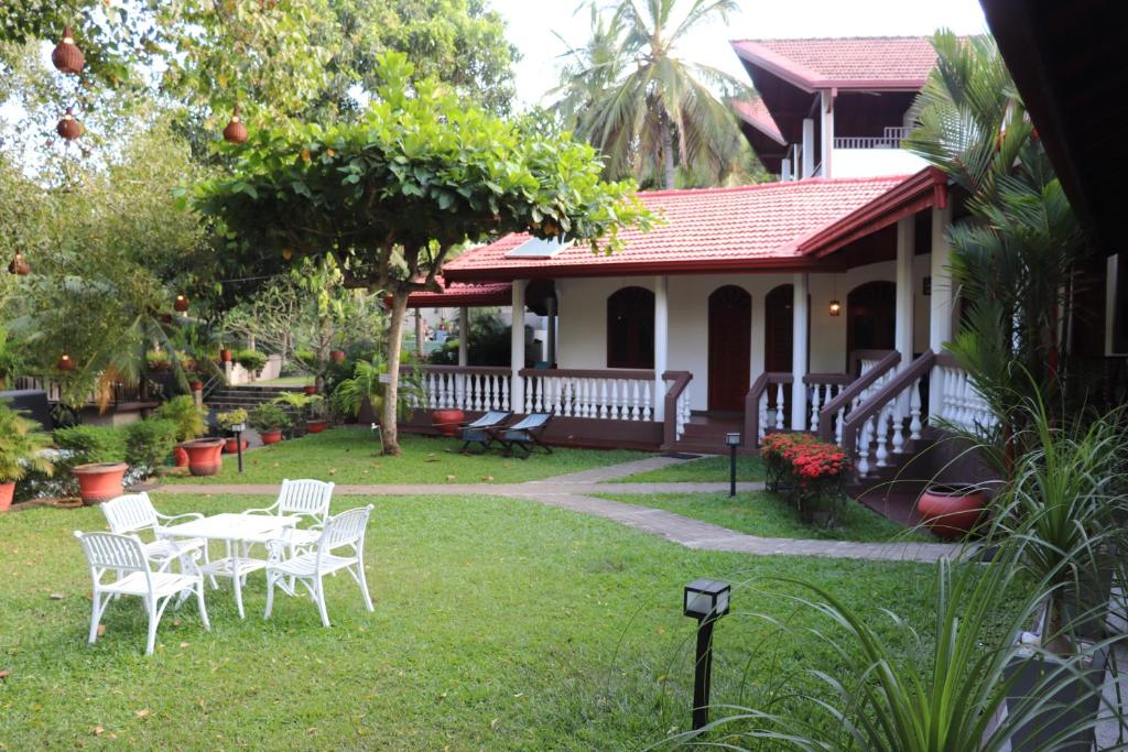 a house with a table and chairs in the yard at Goyambokka Guesthouse in Tangalle