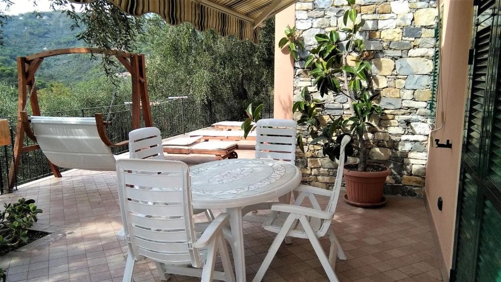 einen Tisch und vier Stühle auf einer Terrasse in der Unterkunft VILLA DIANO CASTELLO in Diano Castello