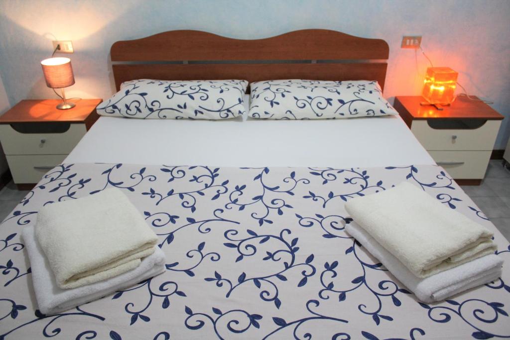 マルティンシクーロにあるMartinsicuro Appartamento 35mq A Pochi Passi Dal Mareのベッド1台(青と白の掛け布団、ナイトスタンド2台付)