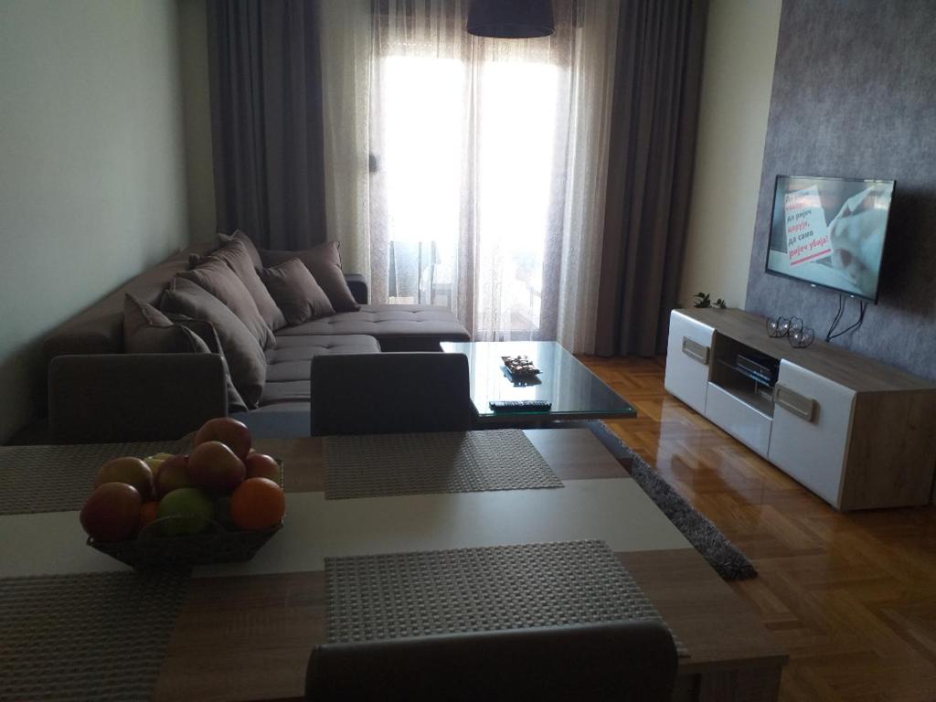 een woonkamer met een bank en een tafel bij Aphrodite Apartment in Podgorica