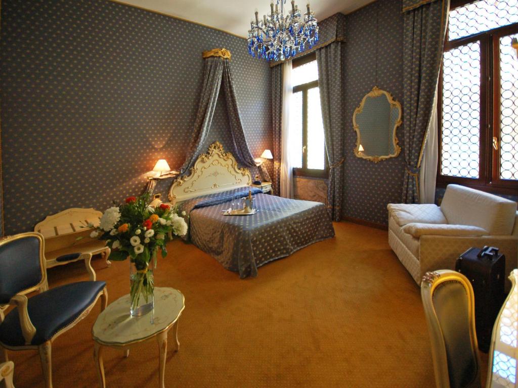 a bedroom with a bed and a couch and a table at Hotel Torino in Venice