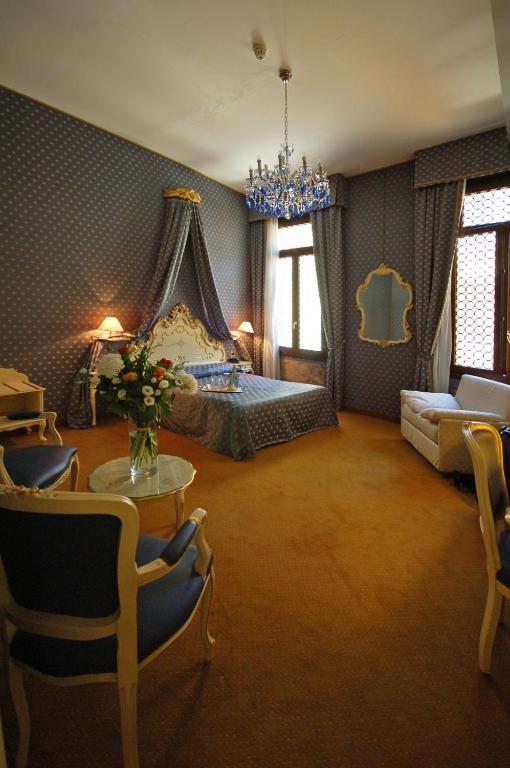 a bedroom with a bed and a table and chairs at Hotel Torino in Venice