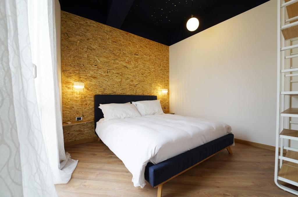 a bedroom with a large bed with white sheets at La luna appartamento con terrazza e due camere in Cagliari