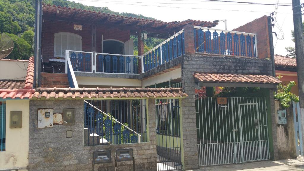 une maison avec un portail et un balcon. dans l'établissement Angra dos Reis Casa a 150 metros da Praia Mambucaba na Vila Histórica divisa com Paraty, à Angra dos Reis