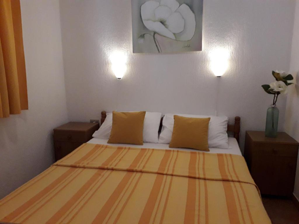 a bedroom with a bed with two pillows at Delfin Apartments in Sveti Juraj