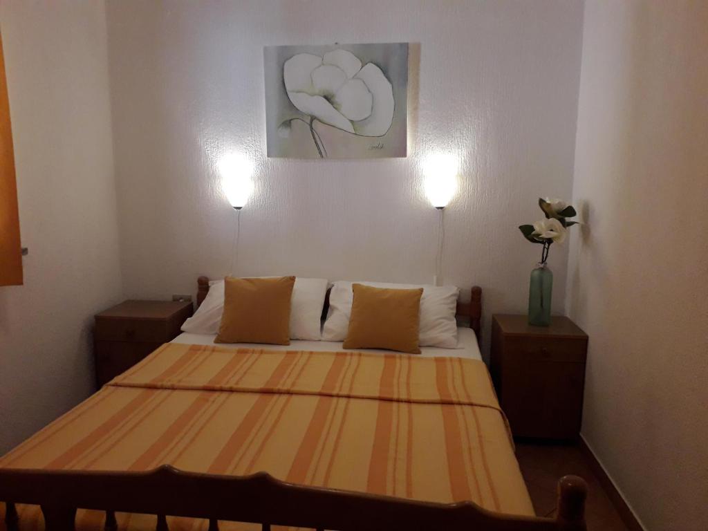 a bed in a room with two lights on at Delfin Apartments in Sveti Juraj