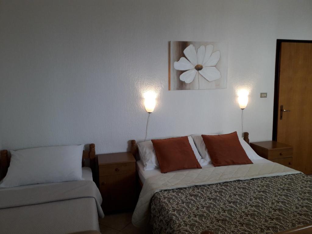 a bedroom with two beds and two lights on the wall at Delfin Apartments in Sveti Juraj