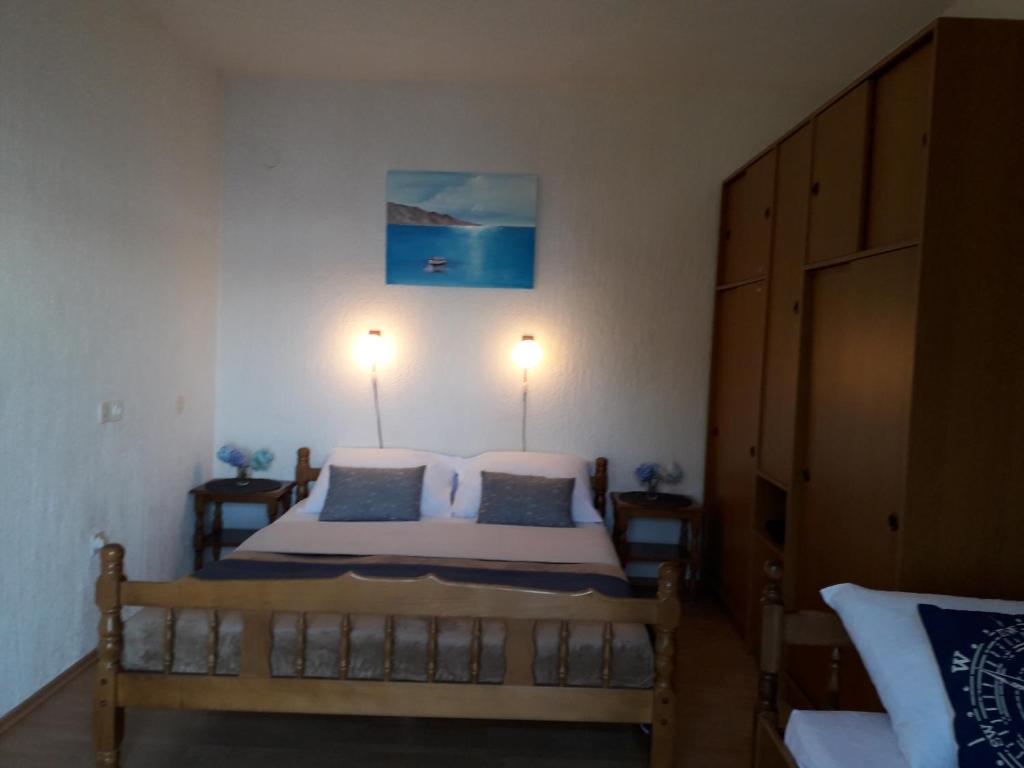 a bedroom with a bed with two lamps on the wall at Delfin Apartments in Sveti Juraj
