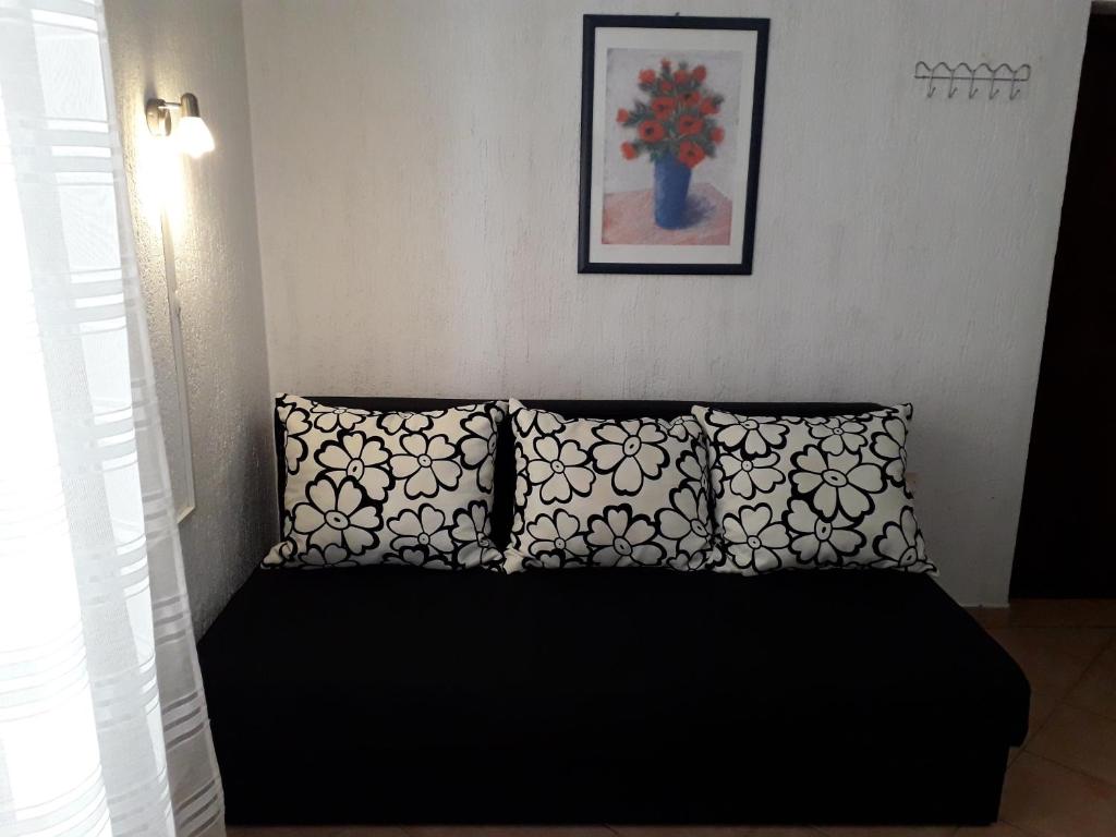a bedroom with a black bed with two pillows at Delfin Apartments in Sveti Juraj