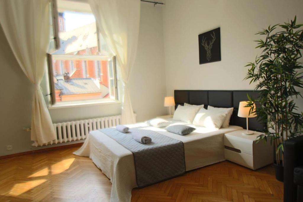 Schlafzimmer mit einem großen Bett und einem Fenster in der Unterkunft Small Market Square - Old Town in Krakau