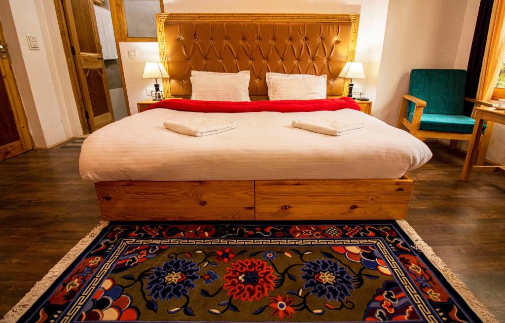 une chambre avec un grand lit et un tapis dans l'établissement Tushita Ladakh, à Leh