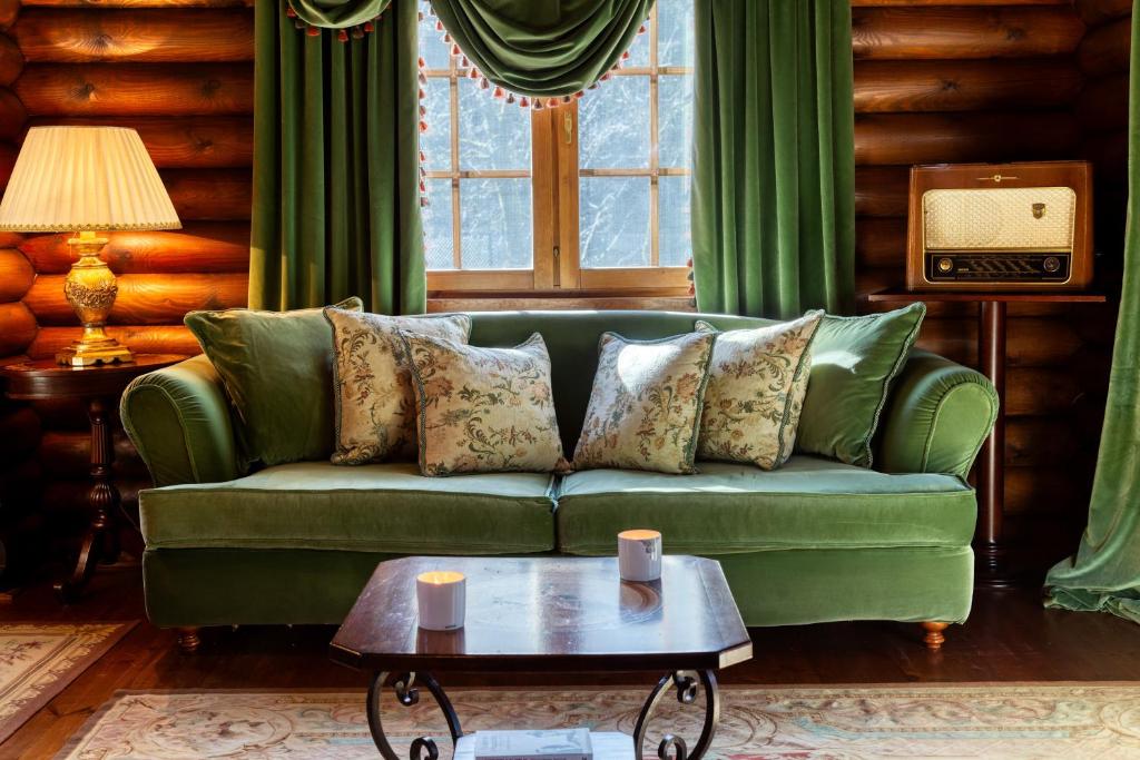 un sofá verde en una sala de estar con mesa en All Seasons Paradise en Khrisovítsion