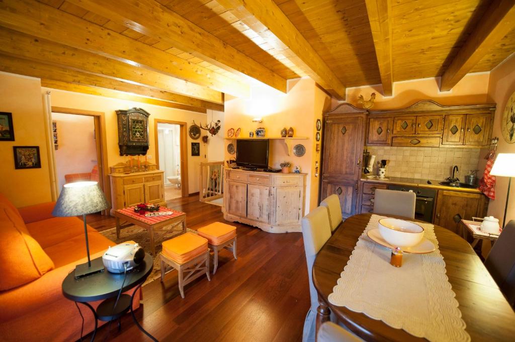 ein Wohnzimmer mit einem Tisch und einer Küche in der Unterkunft Isarco Suite in Sterzing