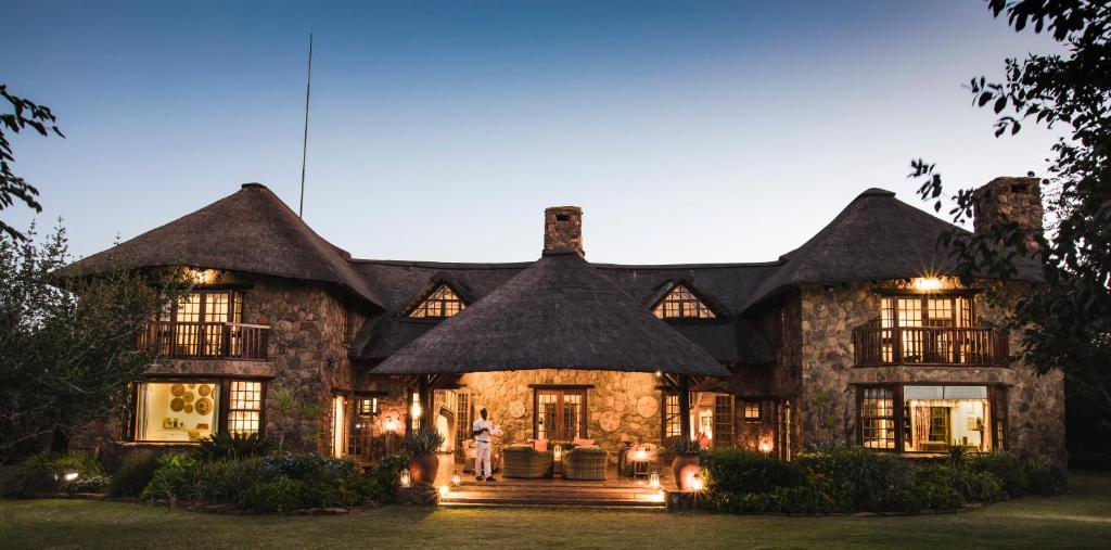 a large house with a thatched roof at Jembisa Bush Home in Melkrivier