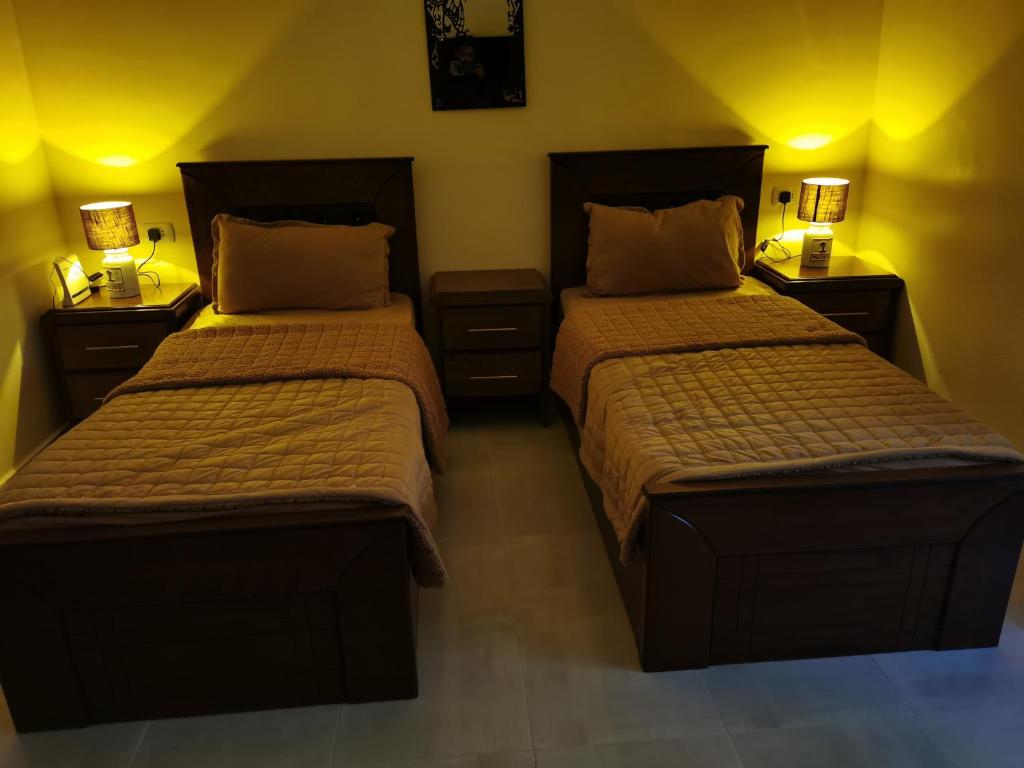 1 dormitorio con 2 camas y 2 mesitas de noche en Petra 555, en Wadi Musa