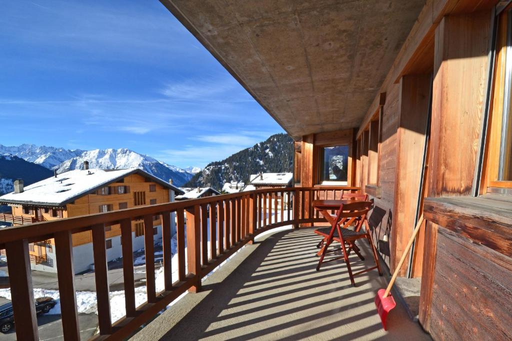 een balkon met een tafel en uitzicht op de bergen bij Snowbird 214 in Bagnes
