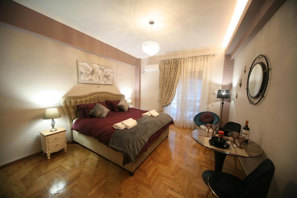 a bedroom with a bed and a table in it at Denise Luxury Apartment-Centre of Athens,Kolonaki in Athens