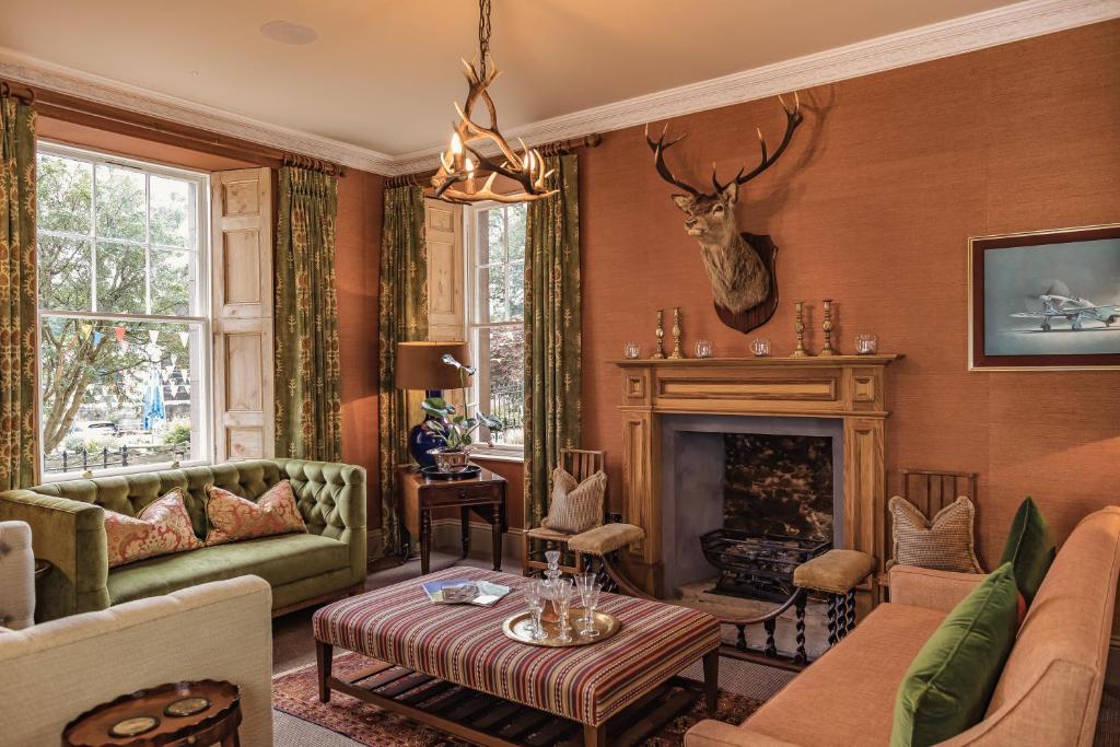 a living room filled with furniture and a fireplace at Tay House in Dunkeld