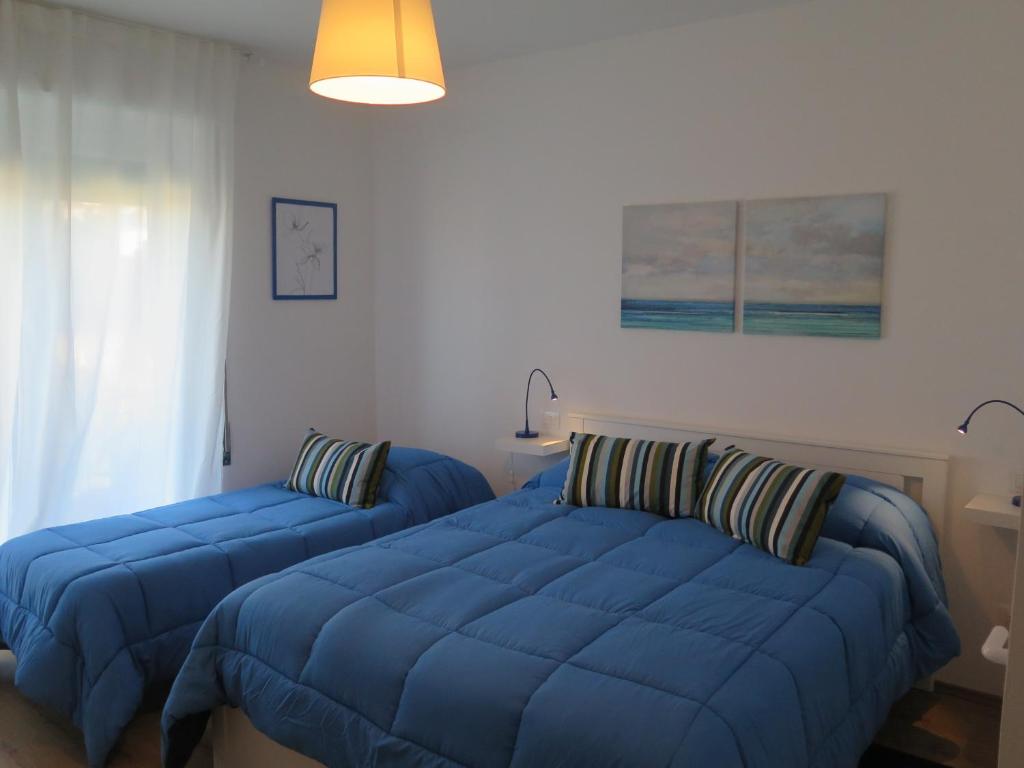2 Betten in einem Schlafzimmer mit blauen Bettdecken in der Unterkunft AnconaBed in Ancona