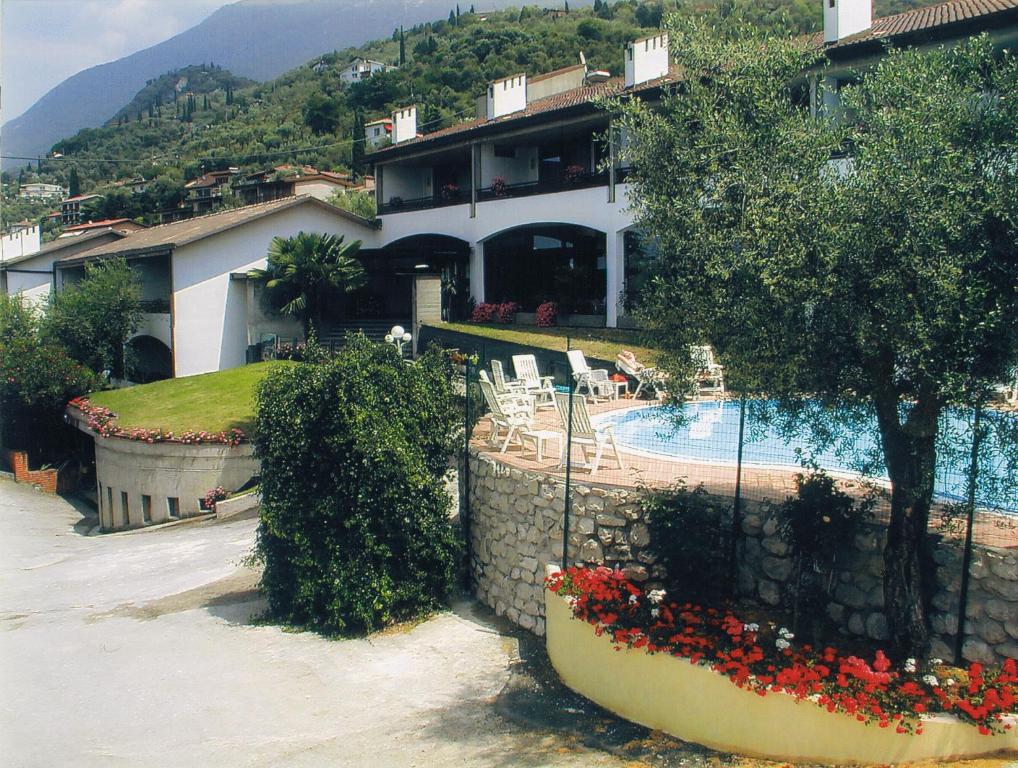 a building with a swimming pool and a house at Hotel Laura Christina in Malcesine