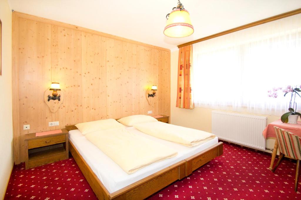 Postel nebo postele na pokoji v ubytování Hotel Garni Hochwurzen