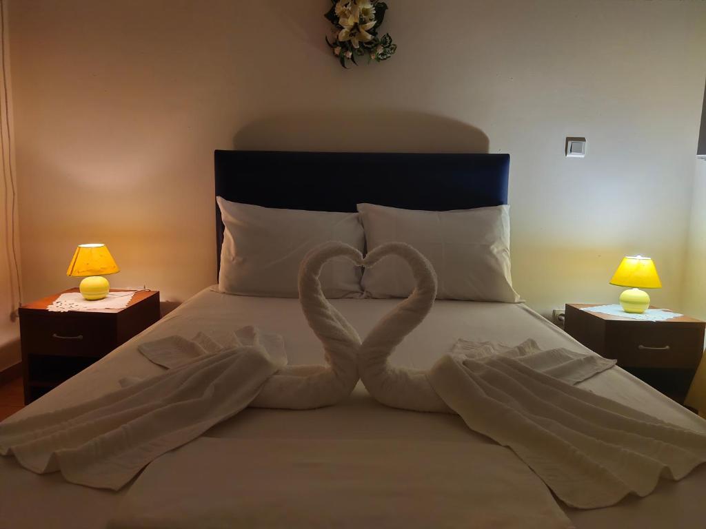 a bed with two heart shaped towels on it at Kea Holidays Houses in Korissia