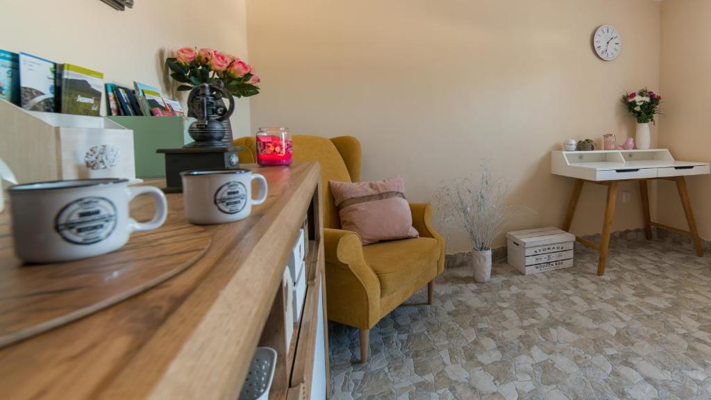 a living room with a desk with a chair and two mugs at Apartmány U Sjezdovky in Kvilda