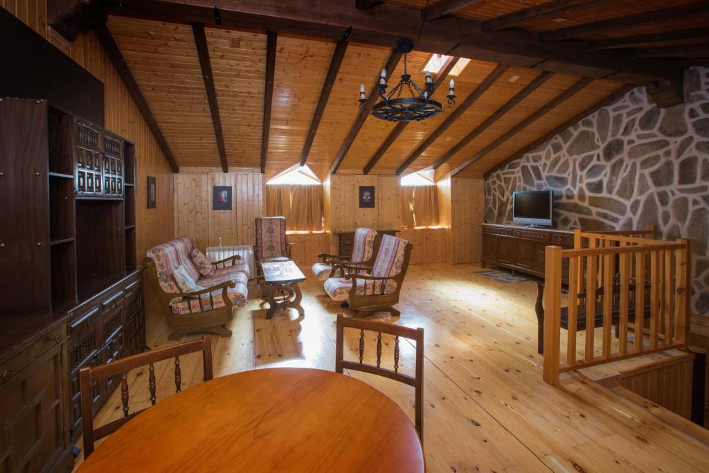 a living room with chairs and a tv and a table at Apartamentos Turisticos Avila Villa Carmen II in Avila