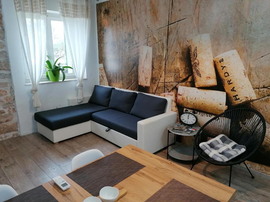 een woonkamer met een blauwe bank en een tafel bij Apartment Anda in Drinovci